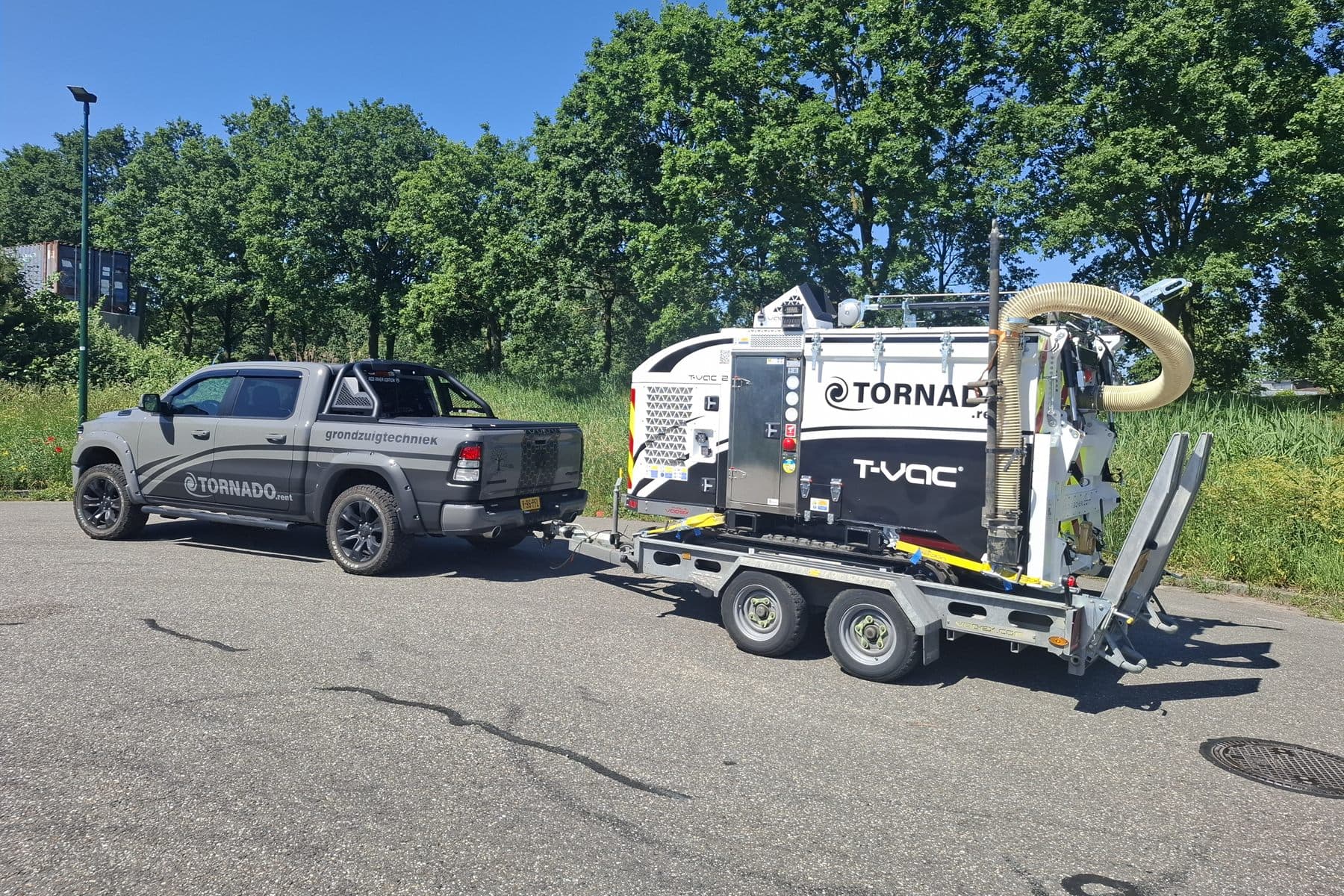VAC-EX grondzuigmachine op trailer achter bedrijfswagen
