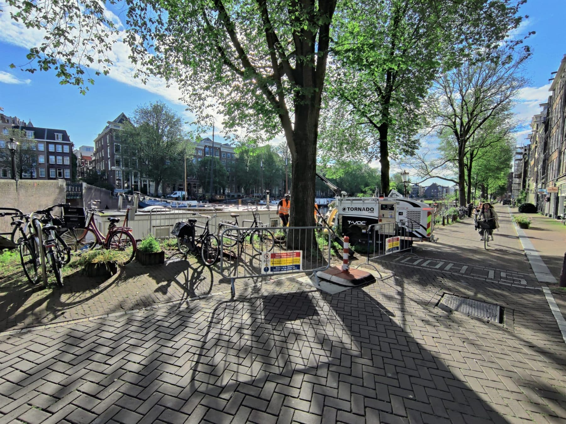 Grondzuigunit van Tornado Rent aan het werk aan een Amsterdamse gracht