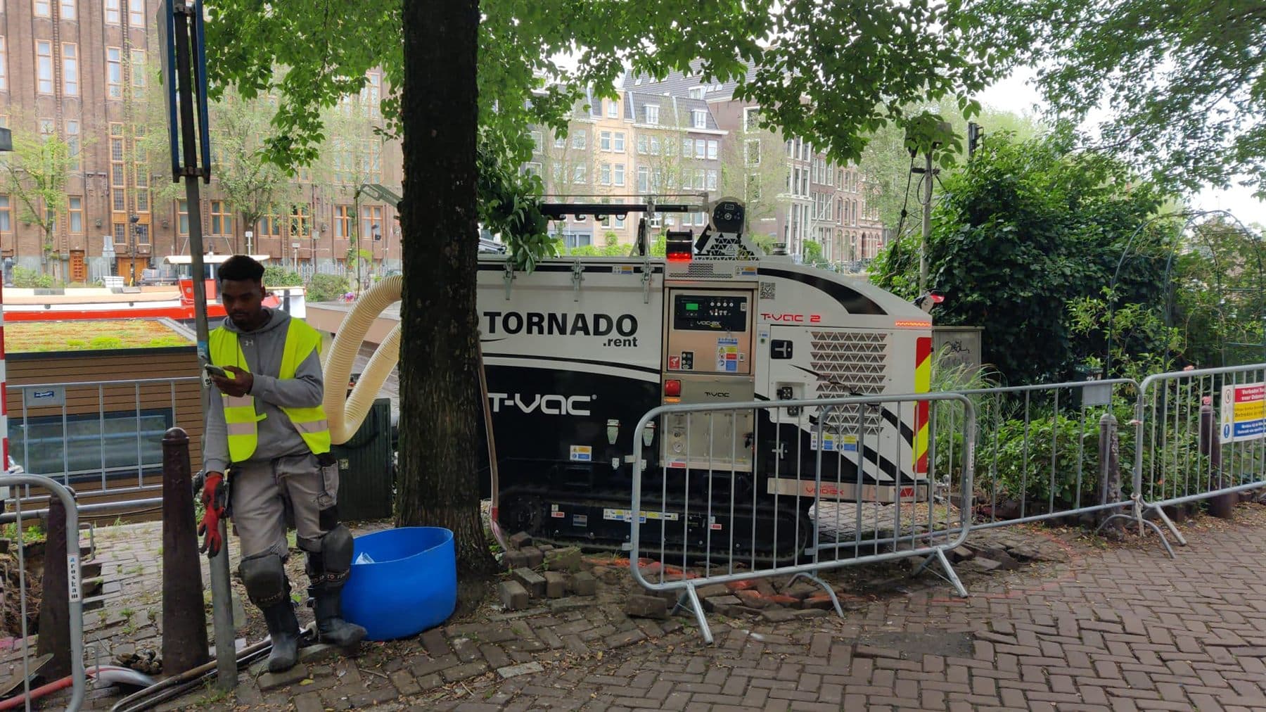 VAC-EX grondzuiger legt kabels en leidingen vrij in een opengelegde straat in Amsterdam
